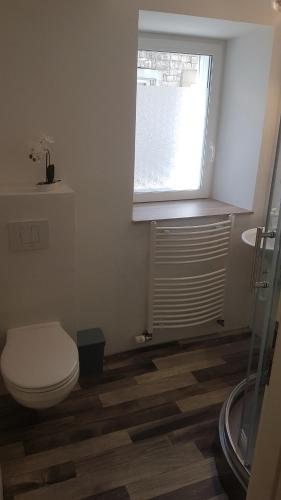 een badkamer met een toilet en een raam bij Ferienwohnung Höhn in Kitzingen