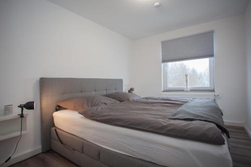 a large bed in a bedroom with a window at WohnZauber in Winterberg