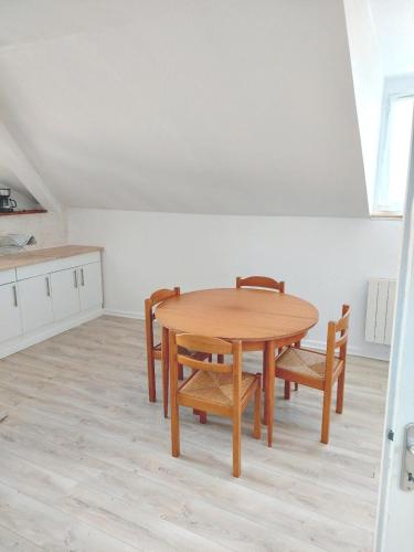 a dining room with a wooden table and chairs at Appartement confortable à Rosny-sous-Bois, 38m² + Vue sur la ville in Rosny-sous-Bois
