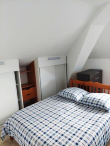 a bedroom with a bed with a checkered blanket at Appartement confortable à Rosny-sous-Bois, 38m² + Vue sur la ville in Rosny-sous-Bois