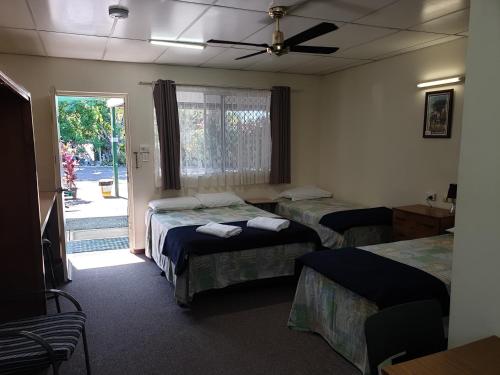 a hotel room with a bed and a desk at Affordable Gold City Motel in Charters Towers