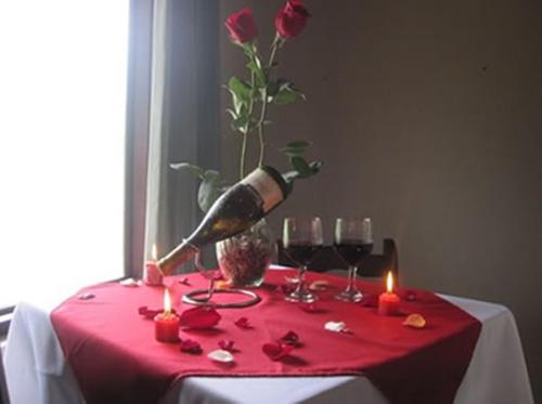 einen Tisch mit Kerzen und eine Vase mit Rosen darauf in der Unterkunft Hotel Vista al Tortuguero in Cariari