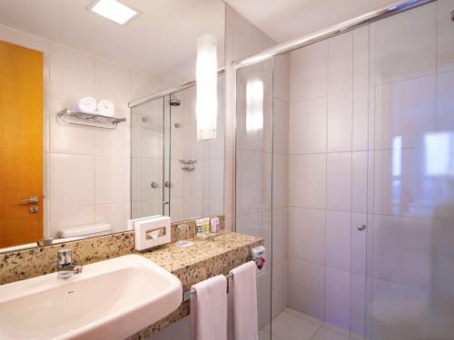 a bathroom with a sink and a shower at Mercure Salvador Boulevard Hotel in Salvador