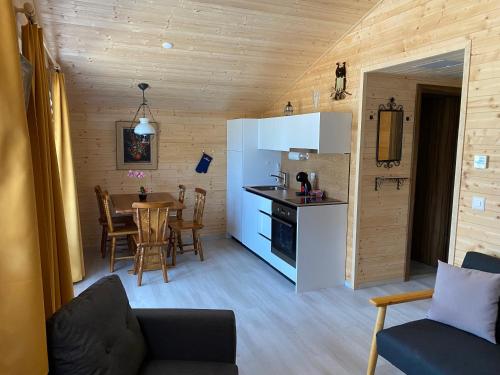 a living room with a kitchen and a table with chairs at la Cibourg, Centre de vacances in Renan