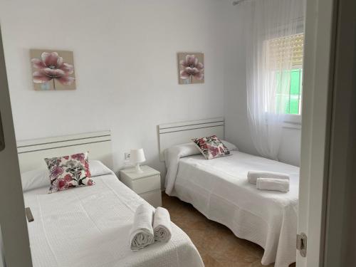 a bedroom with two beds and a window at La Casa de Manolo in Bolonia