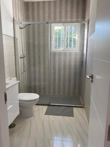La salle de bains est pourvue d'une douche, de toilettes et d'une fenêtre. dans l'établissement La Casa de Manolo, à Bolonia