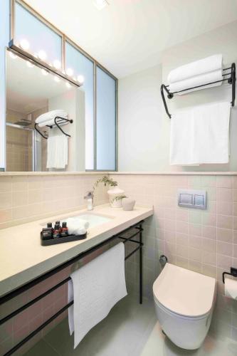 a bathroom with a toilet and a sink with a mirror at Muse Alaçatı in Alacati