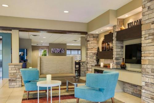 a lobby with two blue chairs and a table at Sleep Inn & Suites Steubenville at the University in Steubenville