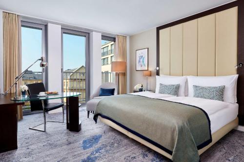 a hotel room with a large bed and a desk at Hotel Kö59 Düsseldorf - Member of Hommage Luxury Hotels Collection in Düsseldorf