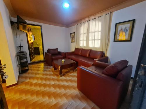 a living room with leather couches and a table at Targafit Hotel & Hammam in Marrakech