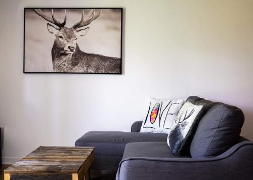 a living room with a picture of a deer on the wall at Condo Hotel Au pied du Mont Orford in Orford