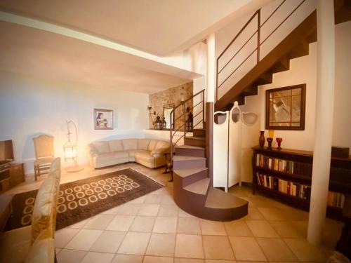 a living room with a staircase and a room with a couch at Appartamento Paolo & Francesca in Verucchio