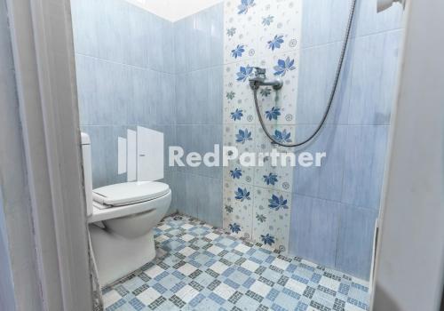 a bathroom with a white toilet and a shower at Nafisa Homestay Syariah Near Jatim Park 3 Batu Mitra RedDoorz in Malang