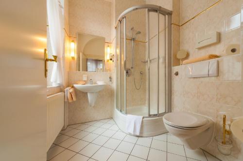 a bathroom with a shower and a toilet and a sink at Hotel Residenz Joop in Magdeburg
