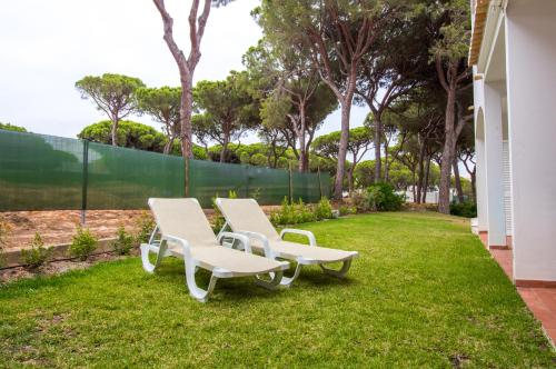 two white chairs and a table in a yard at Açoteias B3 in Albufeira