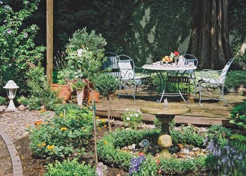 a garden with a table and chairs on a wooden deck at Hotel Residenz Joop in Magdeburg
