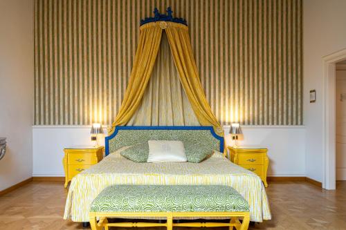 a bedroom with a bed with a blue canopy at Byblos Art Hotel Villa Amistà in San Pietro in Cariano