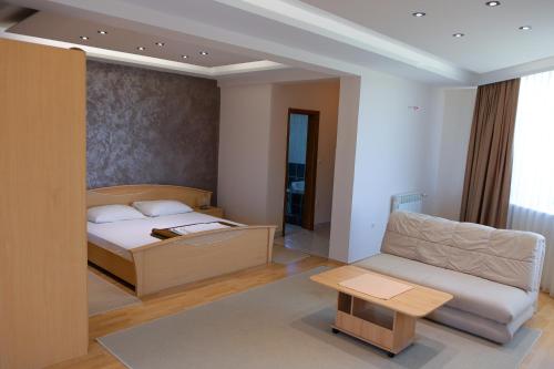 a bedroom with a bed and a couch and a table at Motel Lav in Čapljina