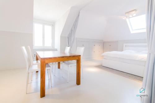 - une salle à manger avec une table, des chaises et un lit dans l'établissement MODERN, MINIMALIST FLAT IN VIENNA, à Vienne