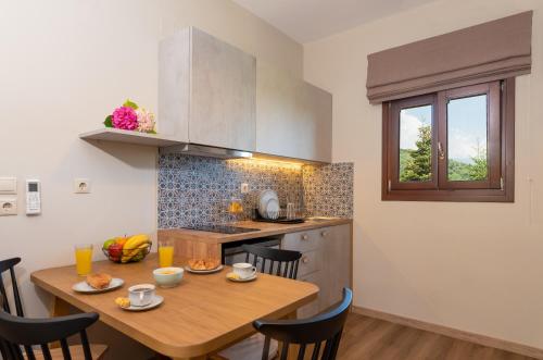a kitchen with a wooden table with chairs and a dining room at Άλυσσος suites in Tsagarada