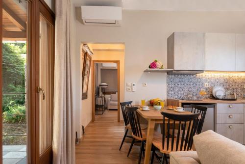 a kitchen and dining room with a table and chairs at Άλυσσος suites in Tsagarada