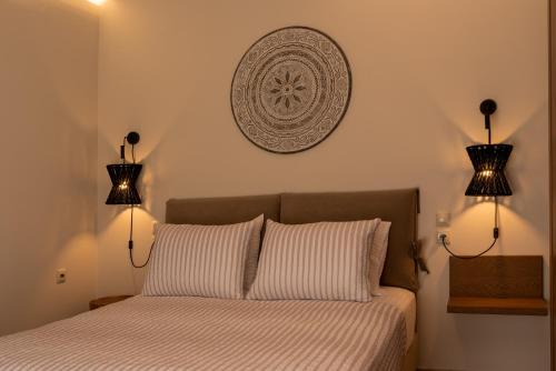 a bedroom with a bed with two lights on the wall at Άλυσσος suites in Tsagarada