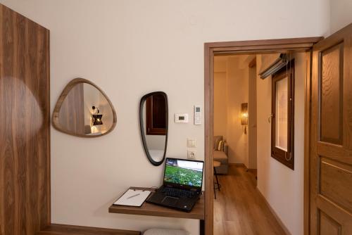 a room with a laptop on a table with a mirror at Άλυσσος suites in Tsagarada