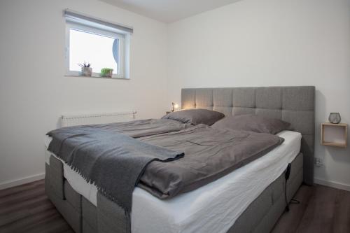 a large bed in a white bedroom with a window at TalBlick in Winterberg