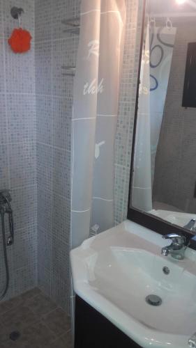 a bathroom with a white sink and a mirror at Παραθαλάσσιο Studio in Agios Nikolaos
