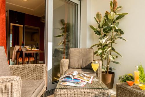 a patio with a table and chairs with a drink at ZENAO MONTREUIL- Croix de Chavaux in Montreuil