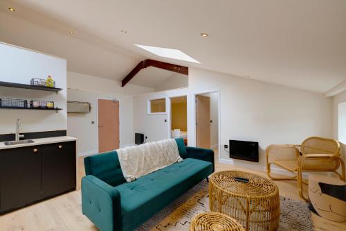 a living room with a blue couch and a tv at CoalShed Lofts in Bristol