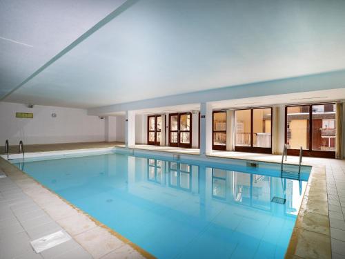 une grande piscine avec de l'eau bleue dans un immeuble dans l'établissement B406- Appartement 2 pieces cabine 6 personnes, à Orcières