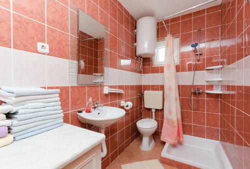 a bathroom with a sink and a toilet and a shower at Apartments Albina in Lopar