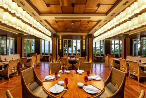 a dining room with a table and chairs and windows at Mandarin Oriental, Sanya in Sanya