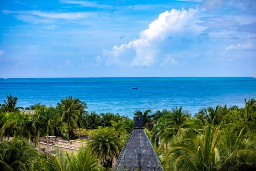 a boardwalk leading to the ocean with palm trees at Mandarin Oriental, Sanya in Sanya