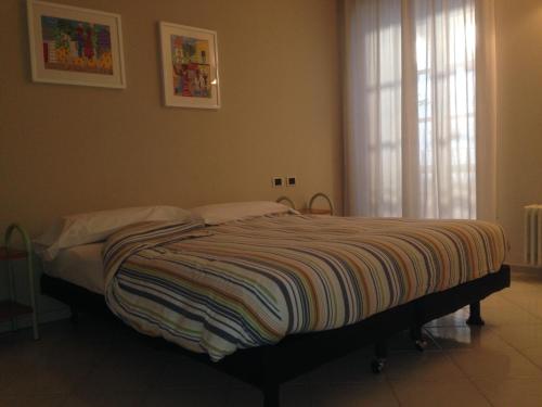 a bedroom with a bed with a striped blanket on it at Casa Vacanza Piazza in Orta San Giulio