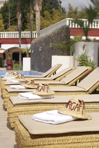 a row of straw chairs with napkins on them at Targafit Hotel & Hammam in Marrakech