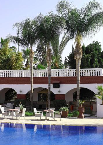 a resort with palm trees and a swimming pool at Targafit Hotel & Hammam in Marrakech