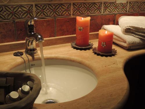 a bathroom sink with two candles on top of it at Casa La Mercedes in Ballobar