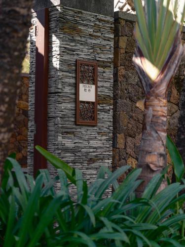 a door in a stone wall with a sign on it at Mandarin Oriental, Sanya in Sanya