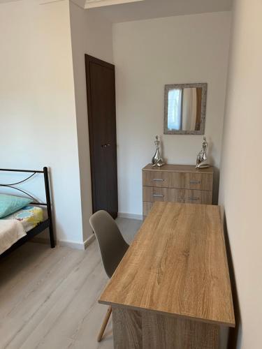 a bedroom with a table and a bed and a mirror at Nantia Apartment in Myrina