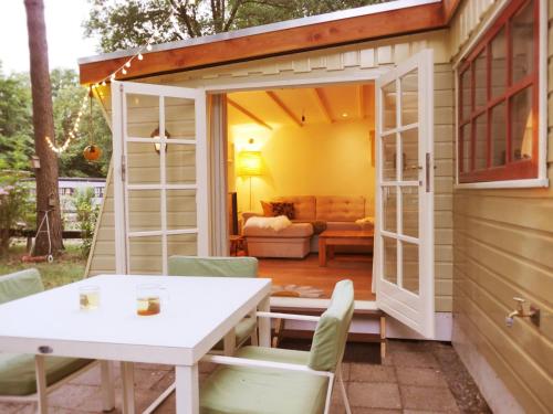 a small shed with a table and chairs on a patio at The Sunbird Inn - with luxurious bathroom & sauna in Diessen