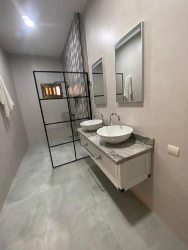 a bathroom with two sinks and a mirror at Hotel Riviera Ramatou Plage in Lomé