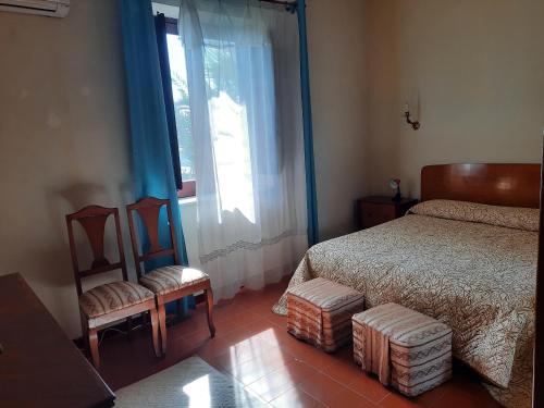 1 dormitorio con 1 cama, 2 sillas y ventana en Casa Valle, en Agrigento