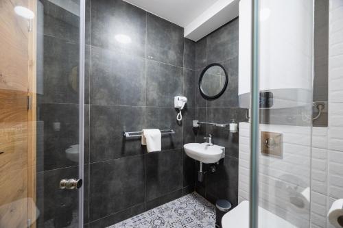 W łazience znajduje się umywalka i przeszklony prysznic. w obiekcie Maglian Campus w mieście Divčibare
