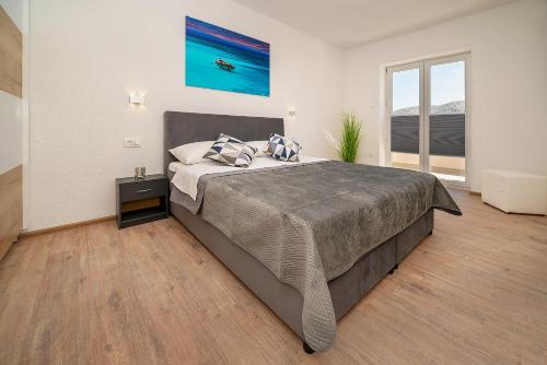 a bedroom with a large bed and a large window at Apartments Gerta with Terrace in Baška