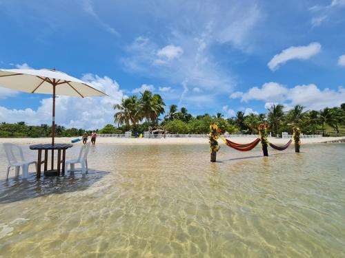 a table and chairs in the water on a beach at Pousada o Forte in Mangue Sêco