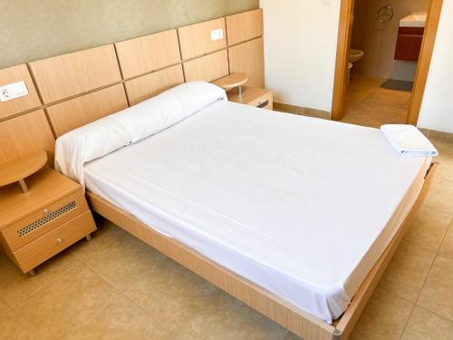 een ziekenhuiskamer met een groot bed met witte lakens bij Apartamento Boutique Sol in Oropesa del Mar