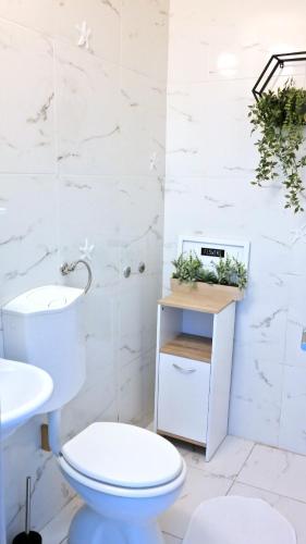 a white bathroom with a toilet and a sink at House Yellow in Šilo