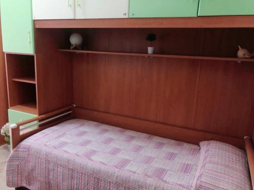 a bed with a wooden headboard in a room at Casa a Gallipoli a 1 minuto dal mare in Gallipoli